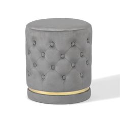 a grey ottoman with gold trim and buttons on it's sides, sitting in front of a white background