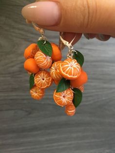 the oranges are hanging from the earrings