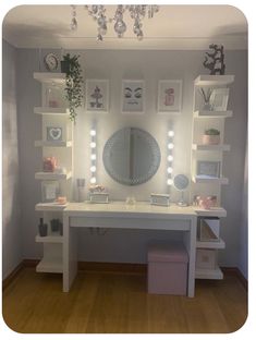 a white desk topped with lots of drawers under a mirror and lights on the wall