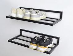 two black shelves holding pairs of shoes on top of each other, one with yellow and white soles