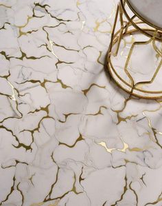 a white marble floor with gold foiling on the top and side tables in the middle