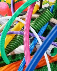 many different colored hoses laying on top of each other next to each other in the grass