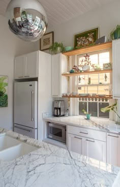 a kitchen with marble counter tops and white cabinets