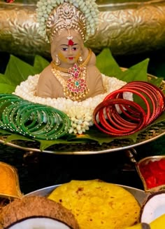 there is a small buddha statue sitting on top of some plates with other food items around it