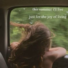 a woman sitting in the back seat of a car with her hair blowing in the wind