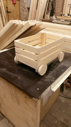 a wooden box sitting on top of a table next to some wood planks and plywood