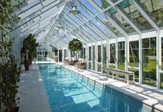 an indoor swimming pool in the middle of a house with glass walls and windows on both sides