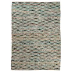 an area rug with various colors and patterns on the floor, including blue, green, beige