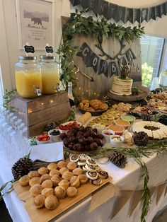 an assortment of food is displayed on a buffet table with pine cones, cookies and orange juice