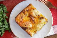 a piece of pizza sitting on top of a white plate