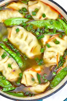 a pot filled with dumplings and green beans