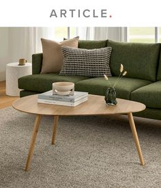 a living room with a green couch and coffee table in front of the sofa is an article about articles