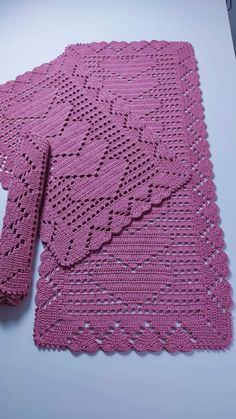 a pink crocheted placemat and napkin on a table