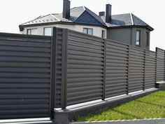 a house behind a fence with two chimneys