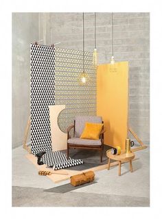 an assortment of furniture is displayed in front of a brick wall with geometric patterns on it