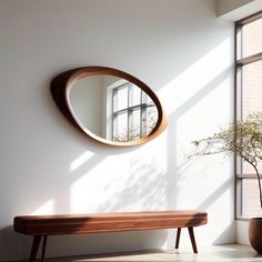 a wooden bench sitting next to a round mirror