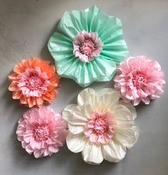 four paper flowers are arranged on a table