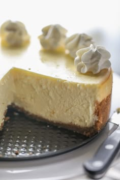 a piece of cheesecake on a plate with a knife and fork next to it