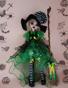 a doll dressed up as a witch holding a broom