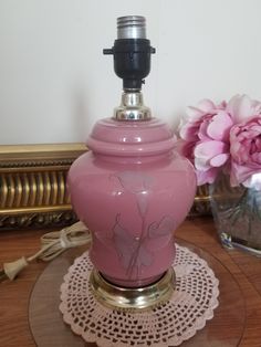 a pink vase sitting on top of a glass table