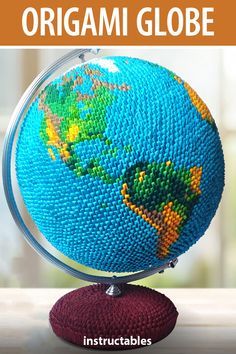 an origami globe on top of a table with text overlaying it