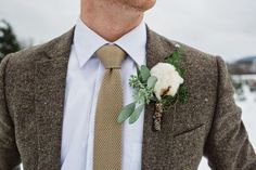 a man wearing a suit and tie with a boutonniere