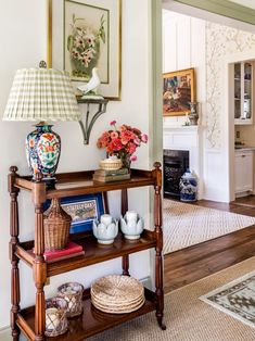 a shelf with vases and flowers on it in a living room next to a doorway