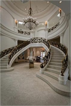 an elegant staircase with chandelier and marble steps in a large home or office