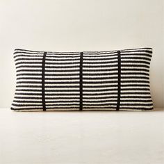 a black and white striped pillow sitting on top of a table