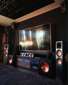 an entertainment center with speakers and a flat screen tv on the wall in front of it