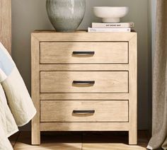 a white vase sitting on top of a wooden dresser