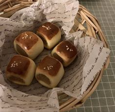 four rolls are sitting in a basket on the table