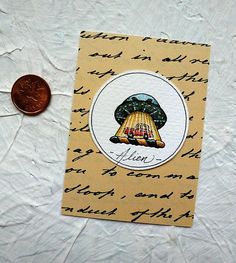 a penny sitting on top of a piece of paper next to a note with an image of a bell