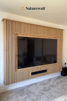 a flat screen tv mounted to the side of a wooden wall in a living room