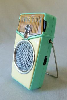 a green and white radio sitting on top of a table next to a metal object