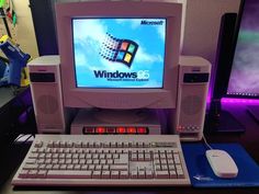 an old desktop computer sitting on top of a desk next to a keyboard and mouse