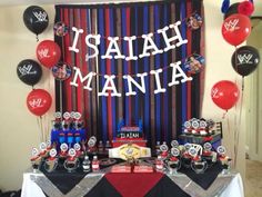 a table topped with balloons and decorations for a wwe birthday party that says, i salah mania