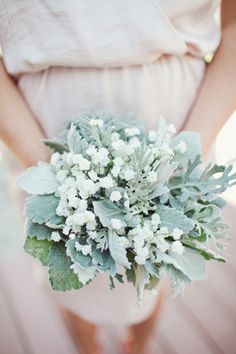 a woman holding a bouquet of flowers in her hands