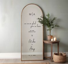 a large mirror sitting next to a table with a potted plant on top of it