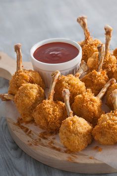 some fried food on a wooden plate with dipping sauce