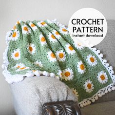 a crocheted blanket with daisies on it