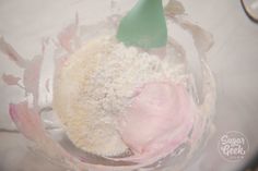 a cake mix in a glass bowl with a green cone on top and pink frosting