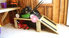 a green lawn mower sitting on top of a wooden shelf