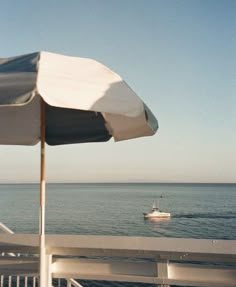 an umbrella and boat in the ocean on a sunny day