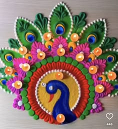 a colorful peacock with candles on it's head is shown in the shape of a circle