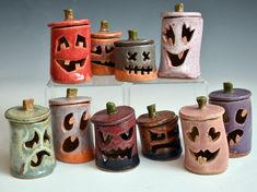 a group of ceramic canisters decorated with pumpkin faces and jack - o'- lanterns