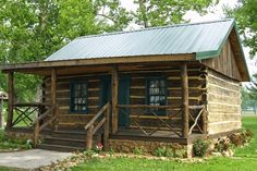 an old log cabin sits in the grass