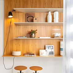 two stools in front of a wooden shelf