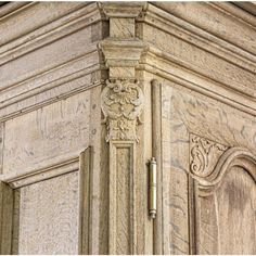 the corner of an old building with carvings on it's sides and door handles