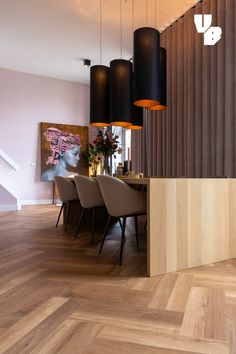 a modern dining room with wood flooring and hanging lights